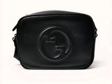 un sac Gucci en cuir noir avec un logo sur le devant