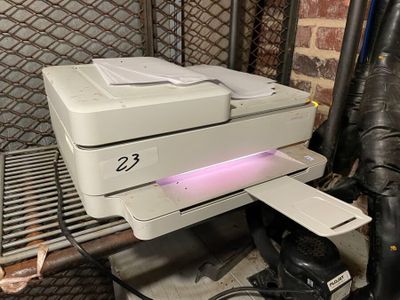 a white printer sitting on top of a metal shelf