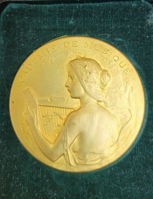 une image représentant une médaille d'or et une femme tenant une harpe