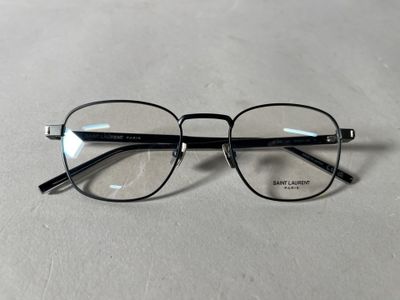 Les lunettes sont noires et ont des verres transparents.
