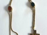 collier composé d'une croix suspendue à une chaîne ornée de perles rouges, bleues et vertes