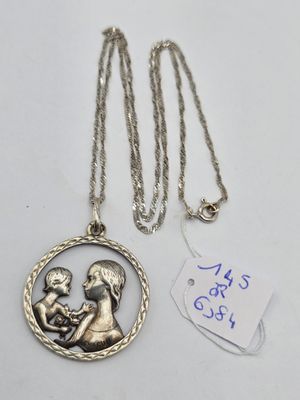 un collier en argent orné de la photo d'une femme tenant un enfant dans ses bras