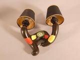 a pair of black and gold wall lights on a white table