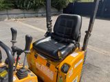 a yellow tractor with a black seat sitting in a parking lot