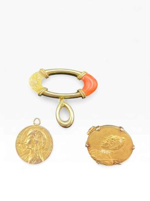 three pieces of gold and coral jewelry including a ring, a coin, and a bracelet