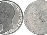 a close up of a coin on a white surface with a white background