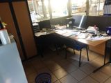 un bureau équipé de deux ordinateurs et d'un réfrigérateur dans une pièce
