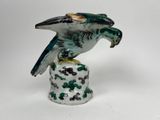 porcelain figurine of a bird on a pedestal with a white background