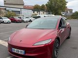 une Tesla Model S rouge garée sur un parking