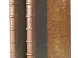 an old book with two leather bindings sitting on top of each other
