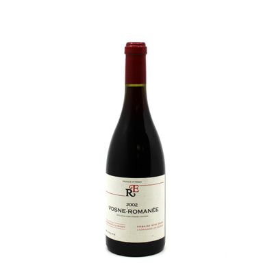 a bottle of red wine sitting on top of a white table