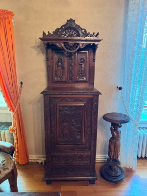 une grande armoire en bois dans un coin du salon