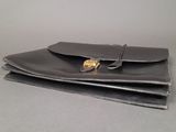 a black leather wallet with a gold clasp on it