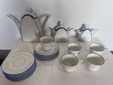 beaucoup d'assiettes et de tasses blanches et bleues sur la table