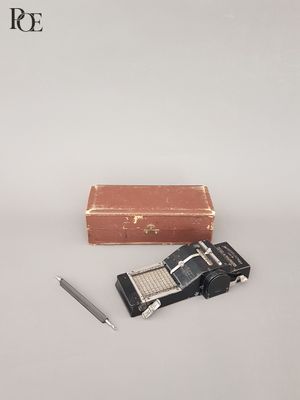 une petite valise et un stylo posés à côté, sur une surface blanche