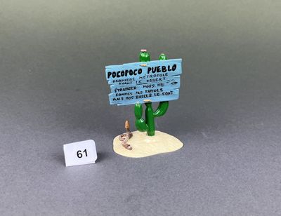 figurine of a cactus plant with a sign on it next to a small number