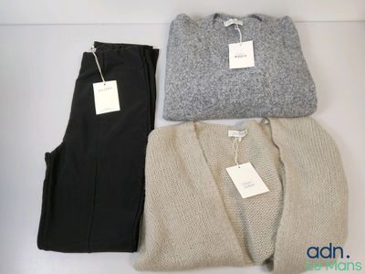 three pairs of sweaters and pants sitting on a white surface
