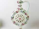 a small white vase with a floral design on it