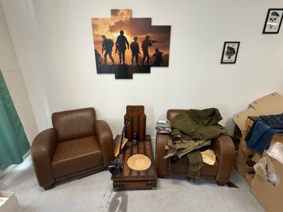 trois chaises et un canapé dans une pièce où est accroché un tableau au mur