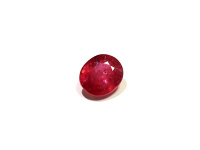 a close up of a red ruby stone on a white surface