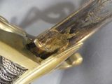 a close up of a knife with a gold handle