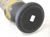 a black vase with a yellow and black design on it