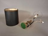 a black canister with a green lid next to a wire