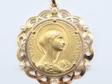 gros plan d'une médaille d'or sur une surface blanche
