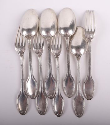 six spoons and a fork are arranged in a row on a white surface