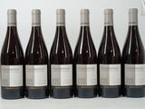 six bottles of wine are lined up in a row on a table