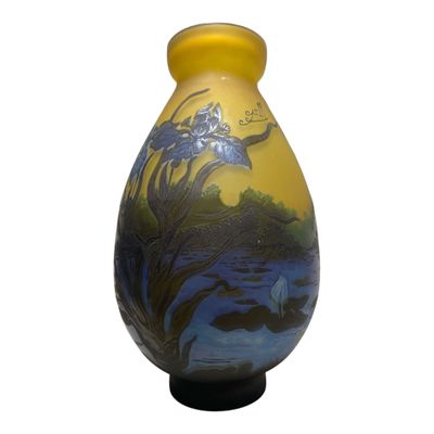 un vase jaune orné d'une peinture, posé sur une table