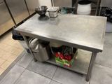 a stainless steel table with pots and pans on it