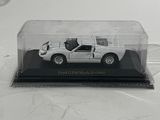a small white car in a clear box on a table