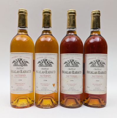 quatre bouteilles de vin sont alignées sur une surface blanche