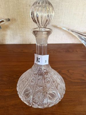 une photo d'une bouteille en verre transparent posée sur une table en bois