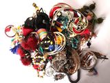 a pile of assorted jewelry on a white surface