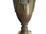 a large green vase sitting on a stand on a white surface