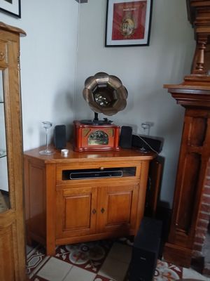 une armoire en bois avec une porte vitrée et une horloge posée dessus