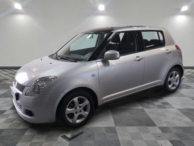 une photo d'un monospace Suzuki argenté garé dans un garage