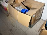 a cardboard box that is sitting on the floor next to a trash can