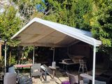 a white canopy over a table and chairs in a yard