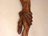 a statue of jesus hanging on the wall next to a cross