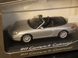 a silver toy car in a clear box on a table