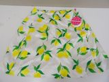 a close up of a white skirt with yellow lemons on it