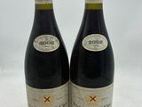 deux bouteilles de vin posées l'une à côté de l'autre sur une surface blanche