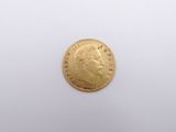 a close up of a gold coin on a white surface