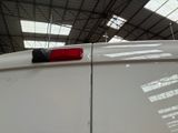 a red light on top of a white car in a building