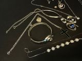 a lot of silver jewelry on a black table