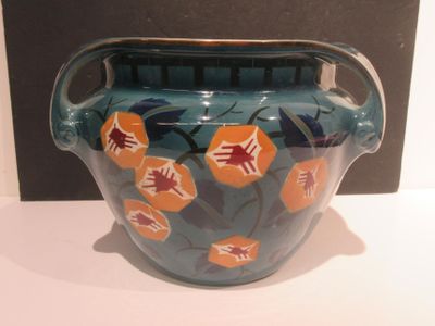 a blue vase with orange flowers on it sitting on a table