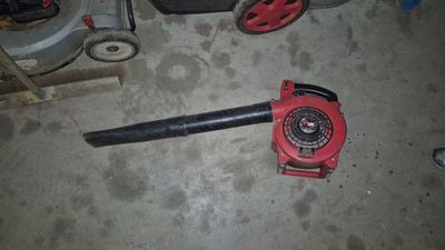 un ventilateur rouge posé par terre à côté d'un ventilateur noir